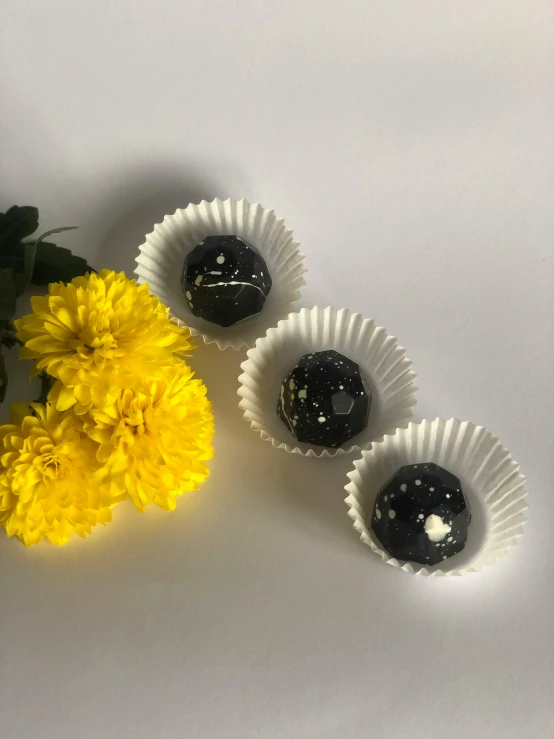 three chocolate balls sitting in the middle of a flower on a table