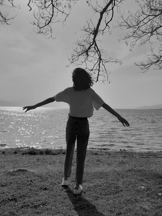 a girl flying a kite while standing on a beach