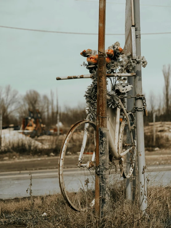 an old bike on the side of a wooden pole with wires