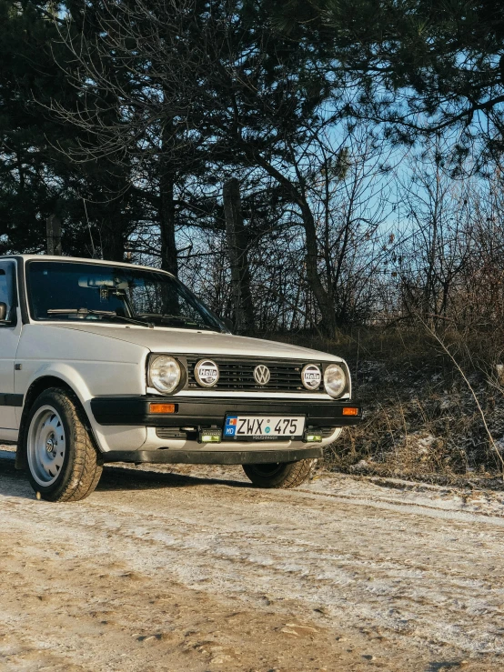 an old car is on the side of the dirt road