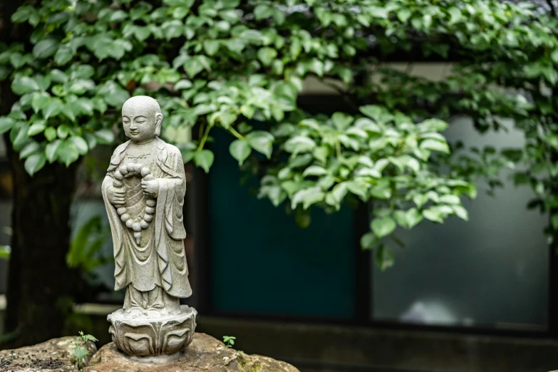 a little statue of buddha holding a book