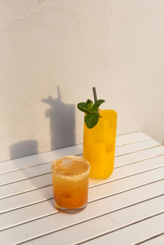 two pitchers with drinks and a drink on a wooden table