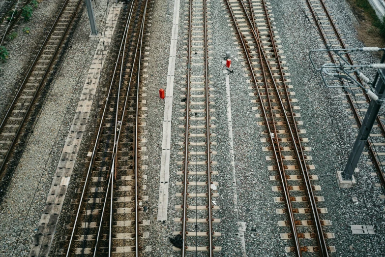 two people stand alone on a train track