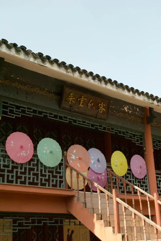 a group of colorful umbrellas hanging over the top of a building