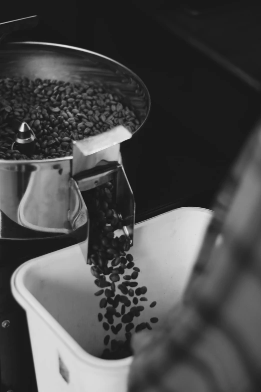 a coffee maker pours coffee beans into a cup