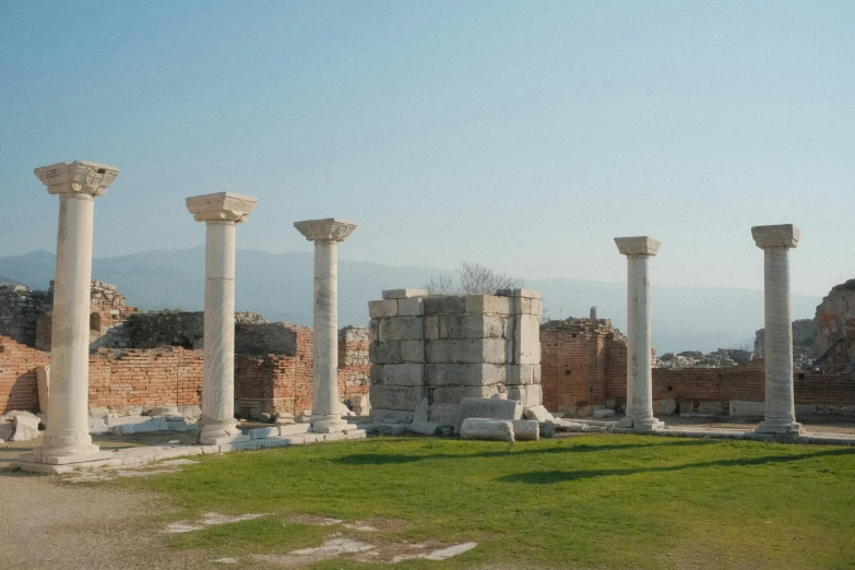 ruins and stone pillars sitting in the middle of a field