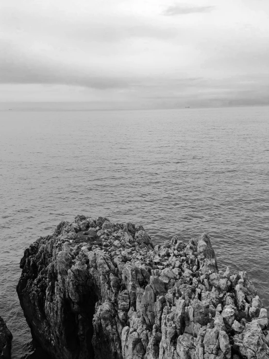 a person sitting on rocks near the ocean