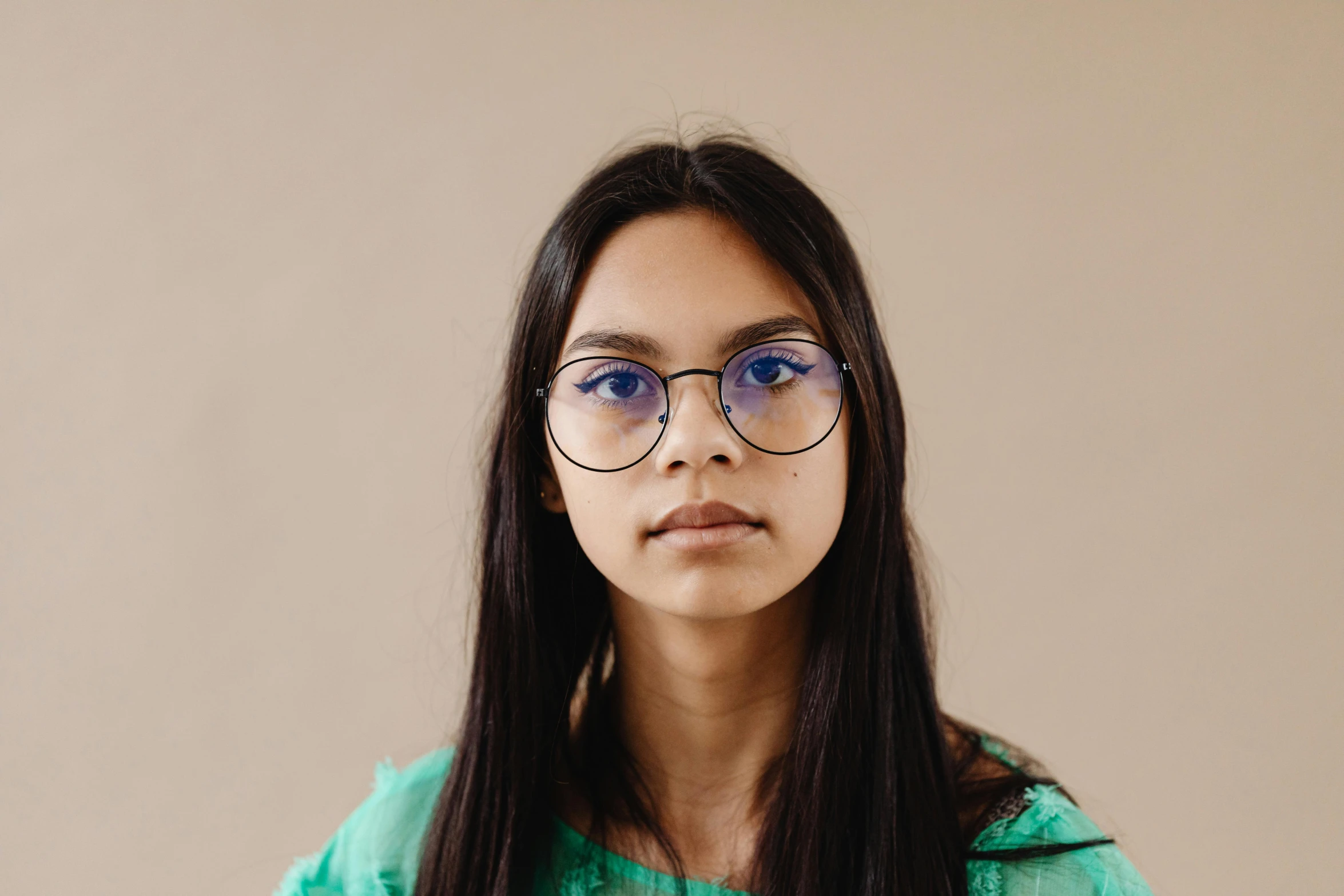 a woman with glasses looking up to the side