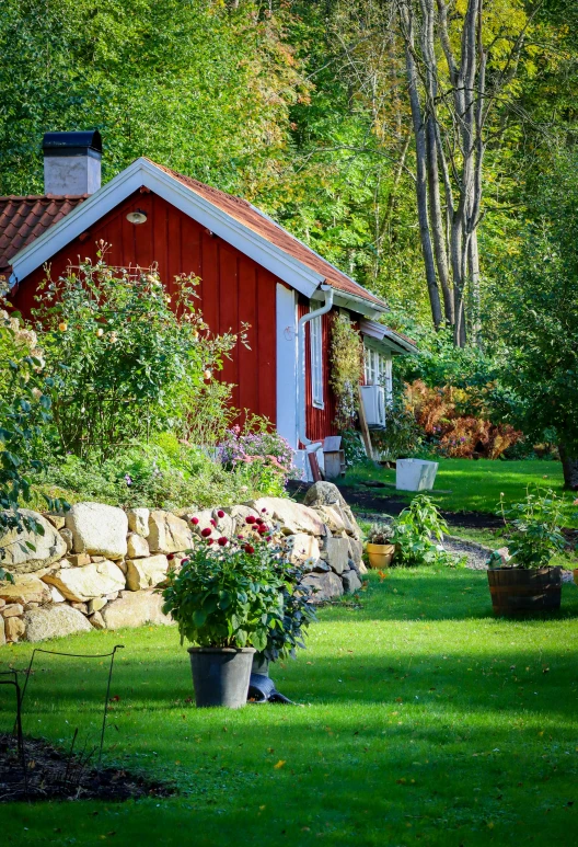 a red building sits in the middle of a green field