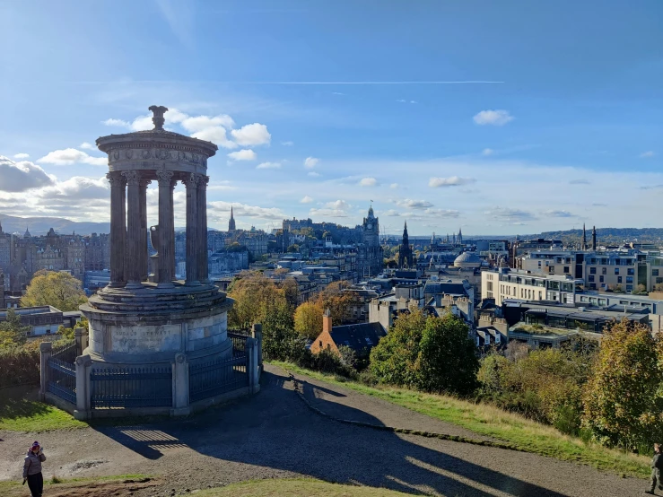 a monument overlooking a city and a blue sky