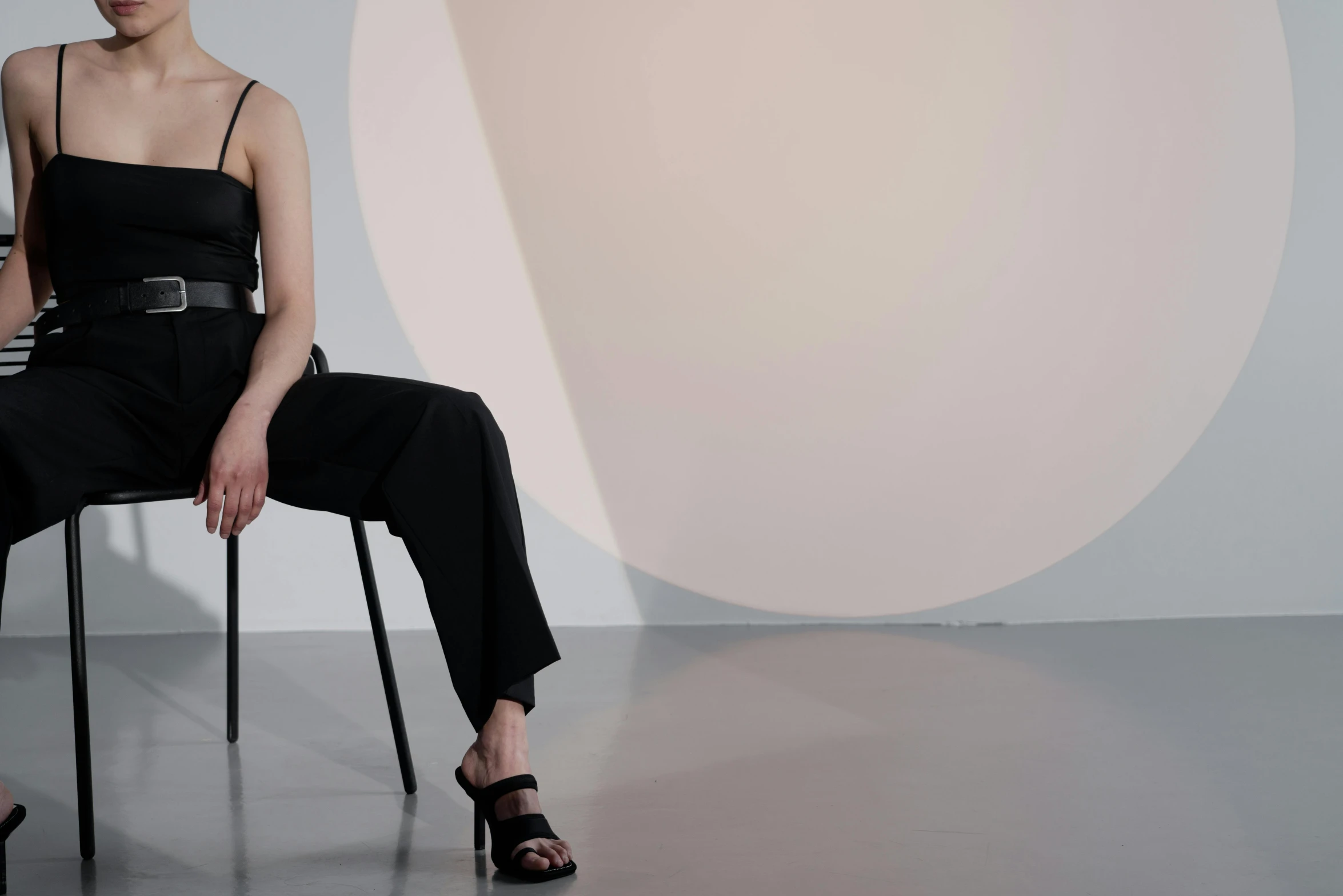 a woman sitting in a chair wearing all black