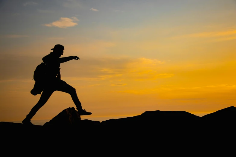 a person walking up a hill at sunset