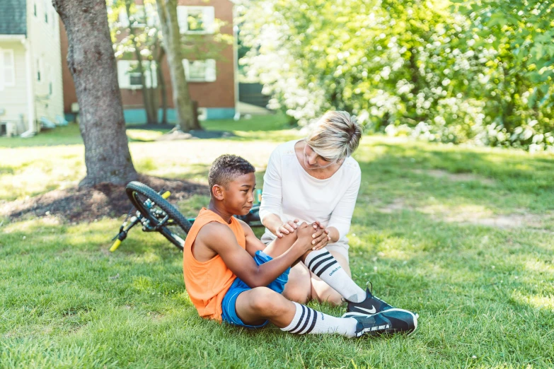 there is a woman sitting next to a small boy who has his hand on the boy's knee