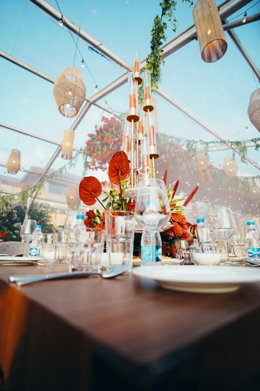 a table set with plates and vases filled with flowers