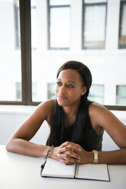 a woman with a pen is sitting at a desk