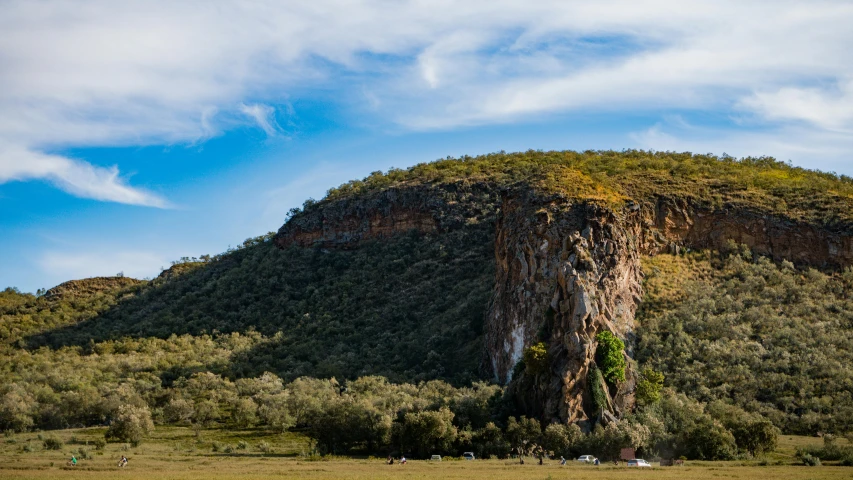 a very tall green mountain covered in trees