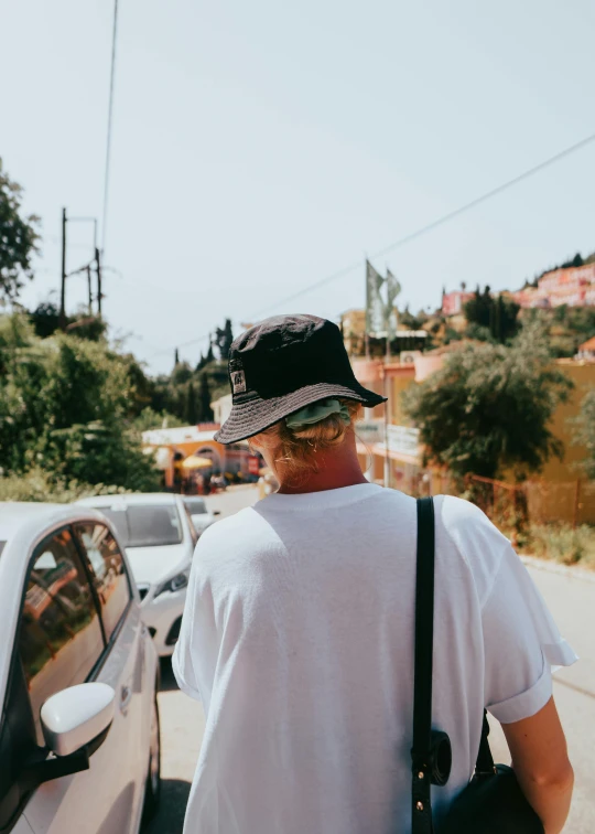 an older man standing by the road with a hat on