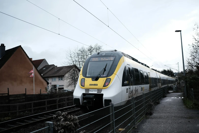 the white and yellow train is leaving the station