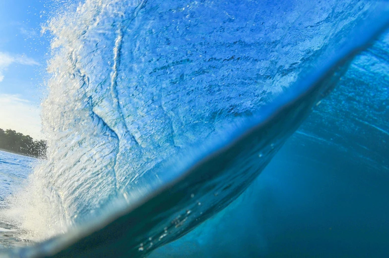 a wave in the ocean is seen from a surfboard