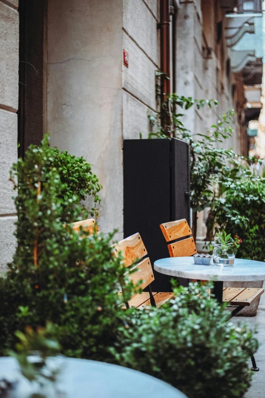 an empty table and chairs set on a city street