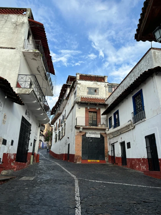 an empty street is lined with narrow buildings