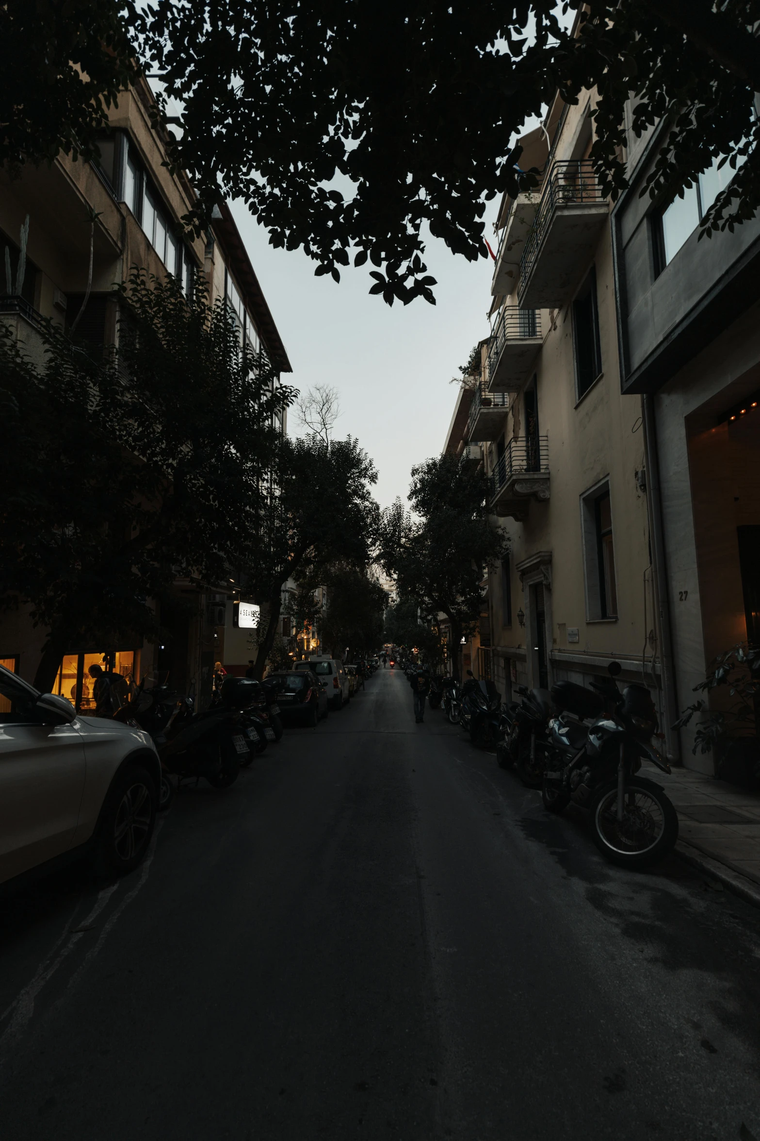 there is a long empty street lined with many parked cars