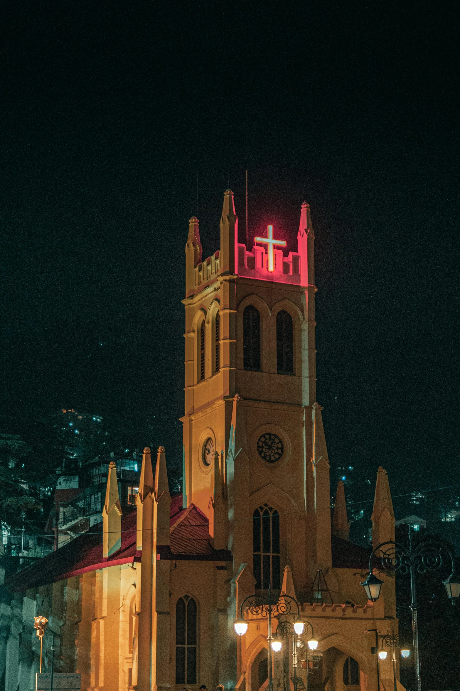 a large building with a tall tower and red lights on it