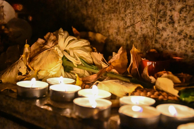 white candles light up with autumn foliage and flowers