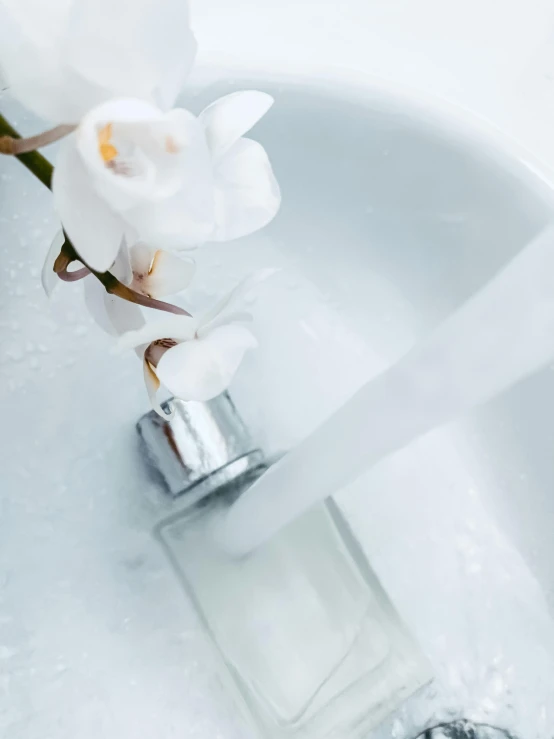 some white flowers in a water glass vase