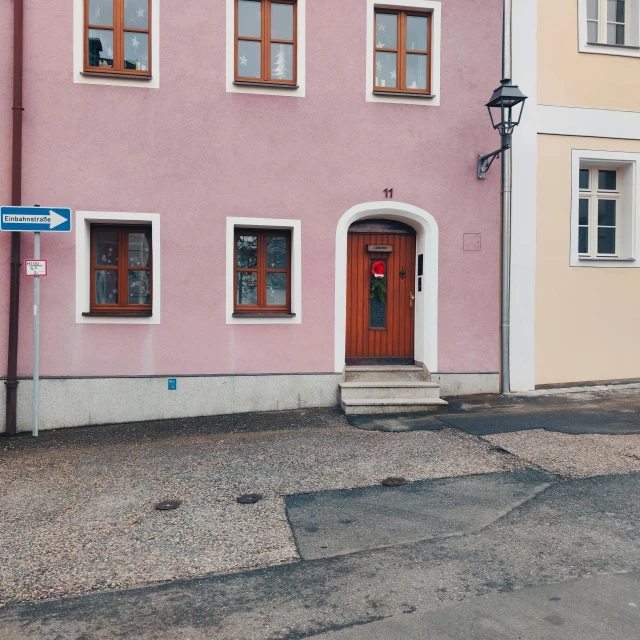 a pink building with a street sign next to it