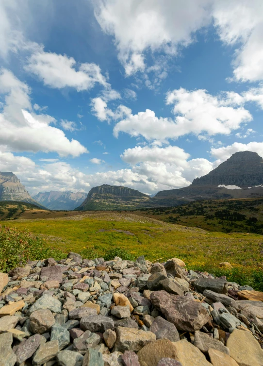 large rocks on a plain and mountains on a cloudy day