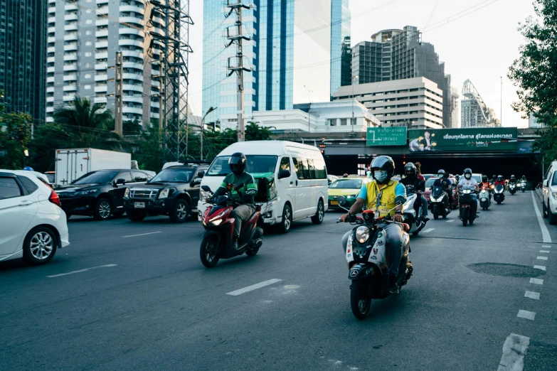 people riding on motorcycles and scooters in traffic