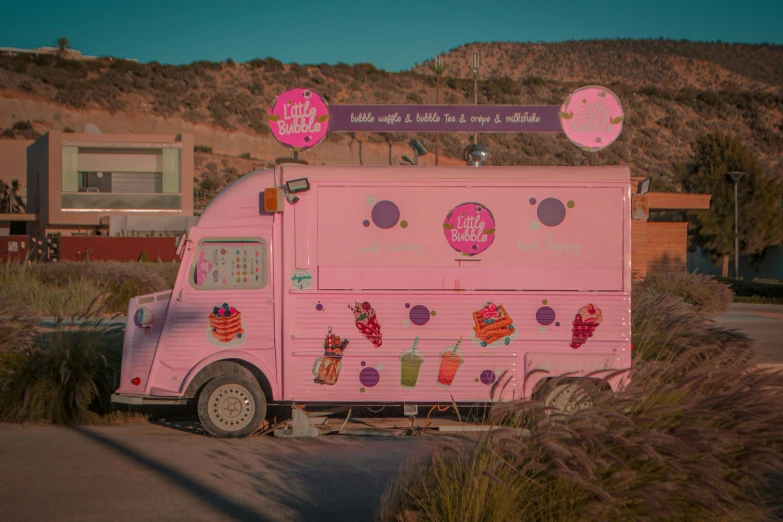 the ice cream truck is parked on the roadside