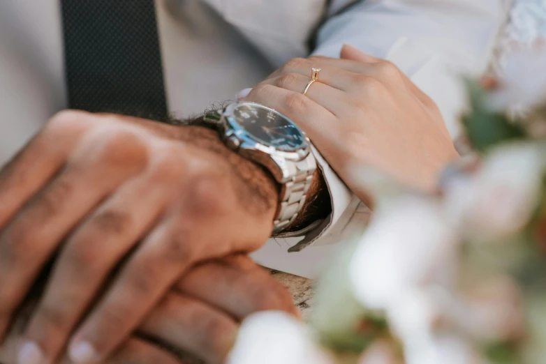 two people hold hands while putting a ring on another person's wrist