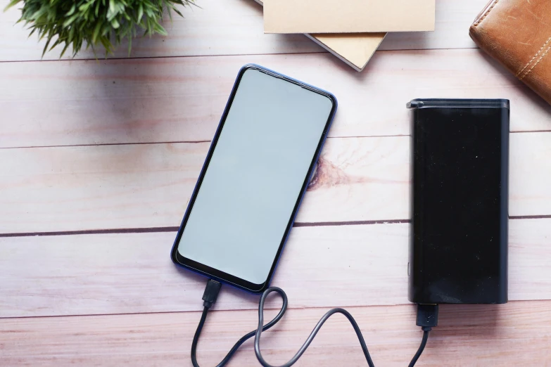 a charger is sitting next to a phone charging on a table