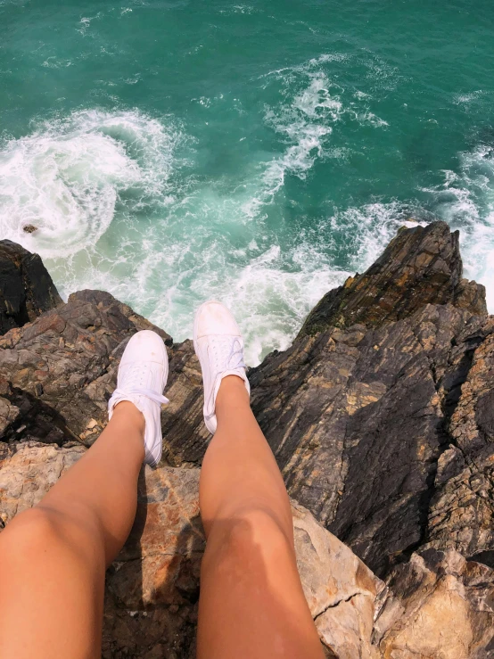 a person standing on rocks over water near the ocean