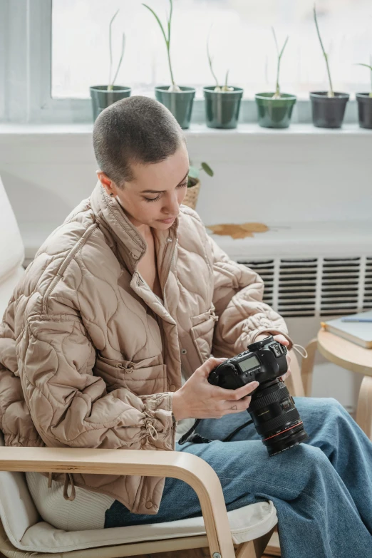 a man sitting in a chair and looking at his camera