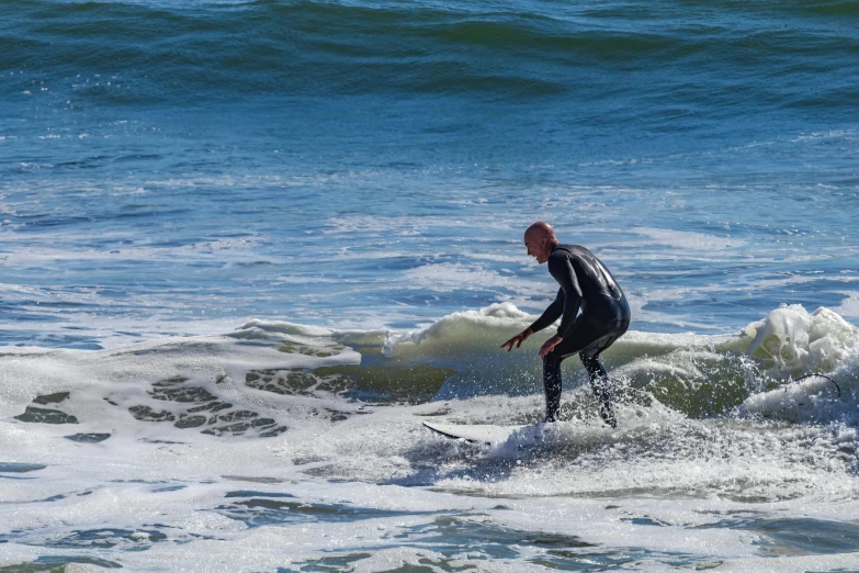 man in black bodysuit surfing on white water