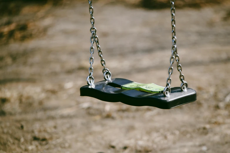 a black swing is set up on a chain