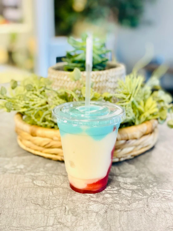 a glass sitting on top of a table filled with green plants