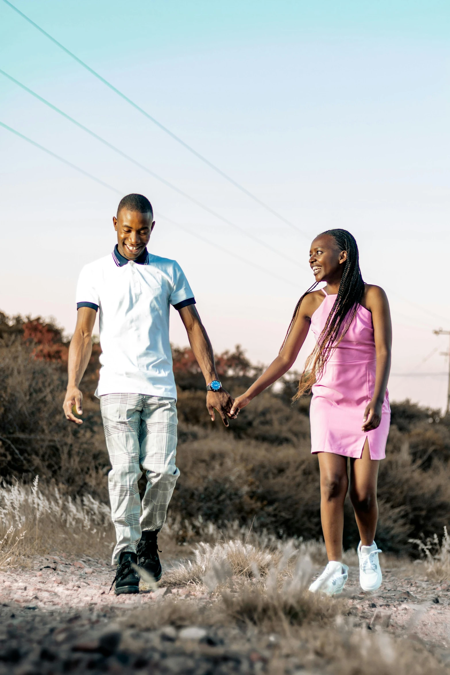 two people walking down the road holding hands