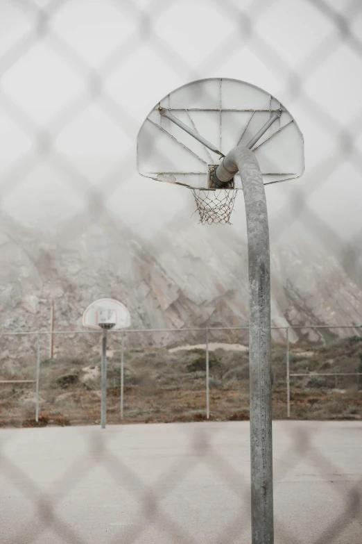 a basketball hoop is hanging in the middle of an open field