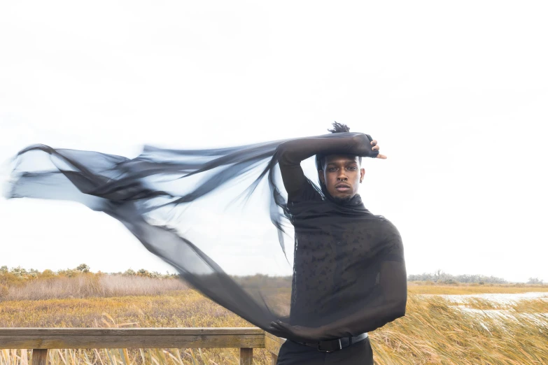 a person in a black shirt with a black scarf around their neck