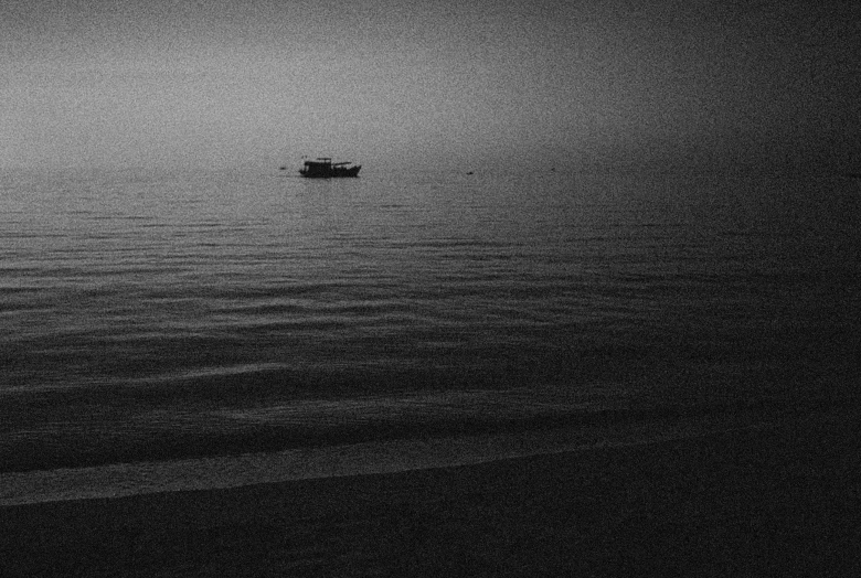 a lone boat in a very dark sea