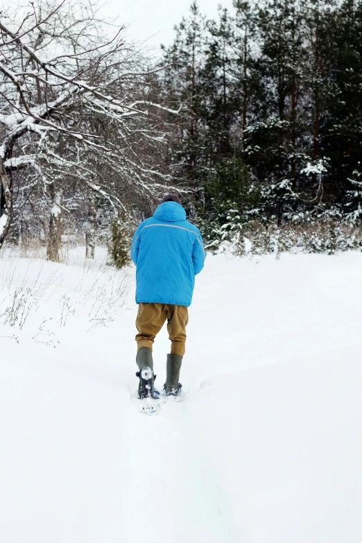 a person wearing a blue jacket skiing down the snow