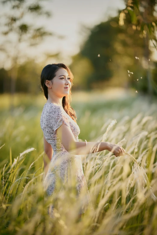 a girl is smiling and holding a dandelion in her hand