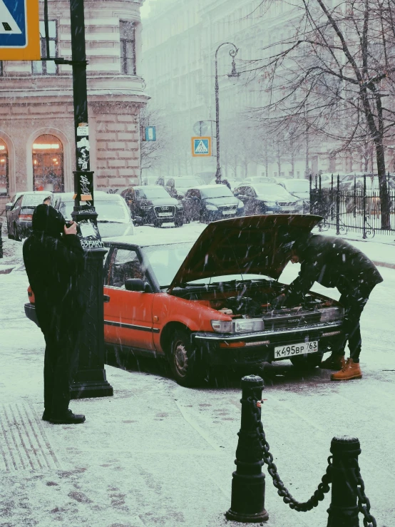 two men working to fix a broken down car