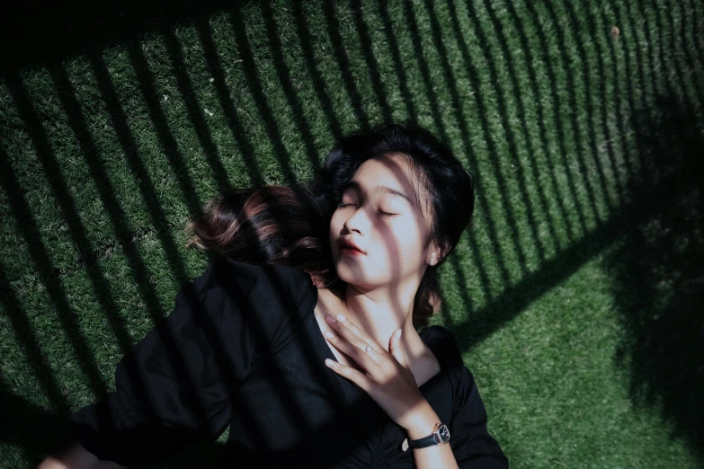 a woman lying on the grass with her hands together