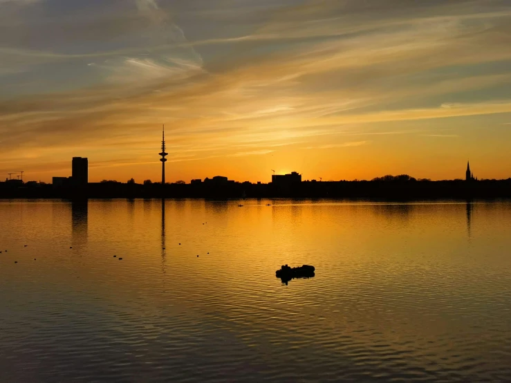 the sun setting over the water with two boats