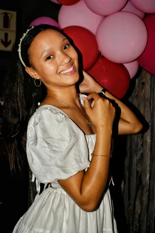 a girl is holding up some balloons on a string